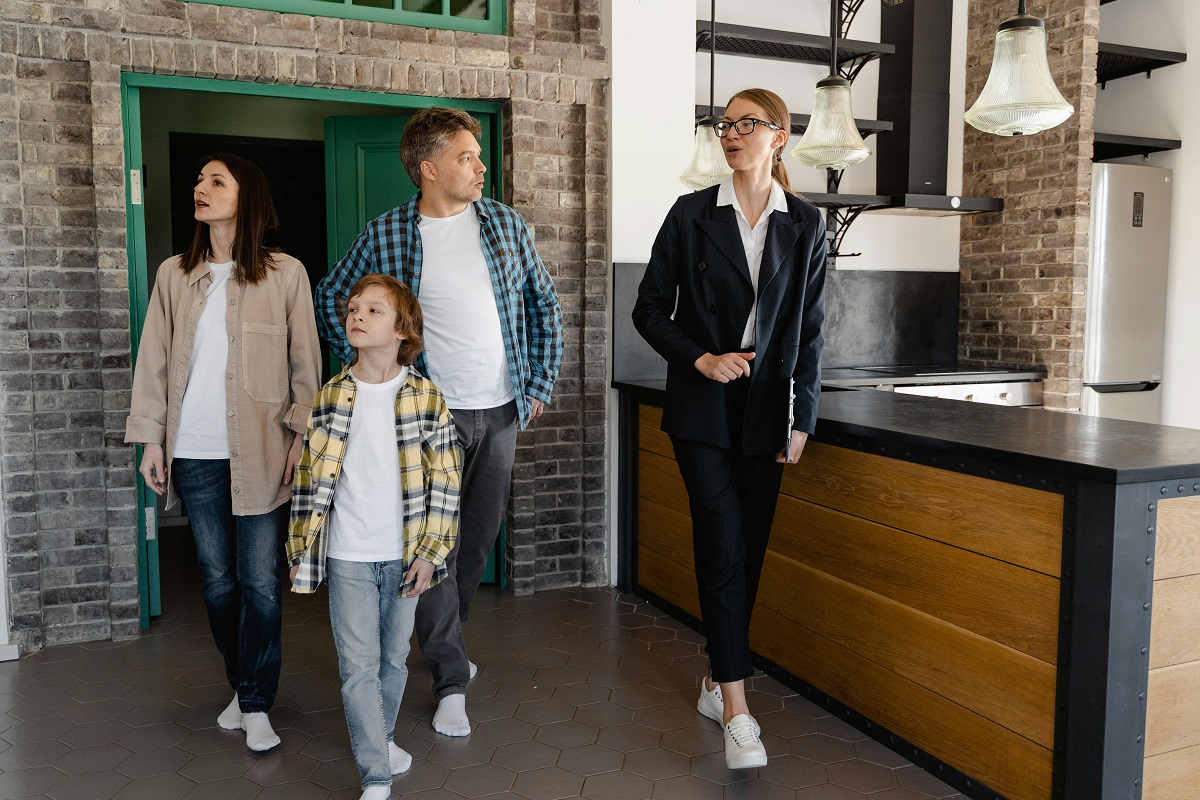 real estate agent touring a family of three through a house